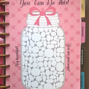 May include: Pink planner with a mason jar design and the text "You Can Do This!" and "Hey beautiful!" and "You are awesome!" The mason jar is filled with white circles. The planner has tabs for July, August, September, and October.
