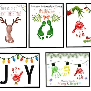 May include: Five framed Christmas art prints. One features a reindeer made from a footprint, another has green footprints with text, and a third shows a handprint with the Grinch. The fourth print says "JOY" with a handprint, and the last says "Merry & Bright".