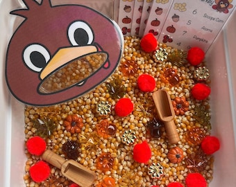 Caja sensorial "Alimenta al pavo": Juego de contar con bellotas, hojas y pompones.