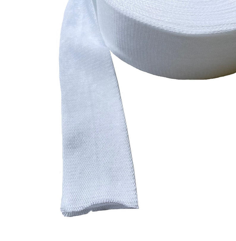 May include: A white cotton webbing strap, rolled up and ready to be used for a variety of crafting projects.