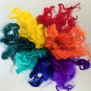 May include: A rainbow of colorful wool fibers, including red, orange, yellow, green, blue, and purple.