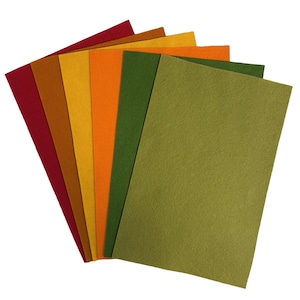 May include: A fan of colorful felt sheets in shades of red, brown, yellow, orange, green, and olive green. The sheets are arranged in a layered, fanned-out pattern, showcasing the variety of colors and textures. Ideal for crafting and DIY projects.