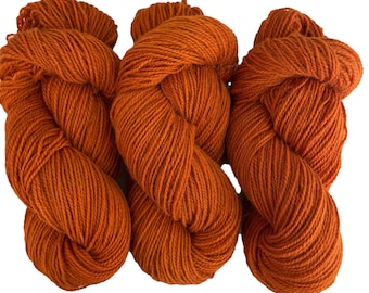 May include: Three skeins of orange yarn, each skein is twisted into a figure eight shape.