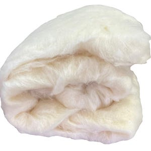 May include: A rolled bundle of soft, off-white fiber material. The fibers are loosely packed and appear fluffy, with a slightly uneven texture. The material is a creamy, natural color, suggesting it may be wool or a similar textile.