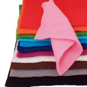 May include: A stack of felt fabric sheets in various colors, including black, gray, brown, white, purple, blue, green, orange, and red. A pink felt sheet is folded and placed on top of the stack.