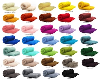 May include: A collection of colorful wool roving in various shades, including natural off-white, bright yellow, red, and black. Each color is labeled with its name. The wool is soft and fluffy, ideal for fiber art projects.