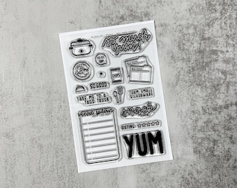 Op de afbeelding: Transparante stempelset met diverse voedselgerelateerde pictogrammen en zinnen zoals "So Much Yum!", "Chips" en "Take Me to a Taco Truck". Bevat afbeeldingen van een pot, een taco, een vork en mes en een notitieblok. Het woord "YUM" is ook inbegrepen.
