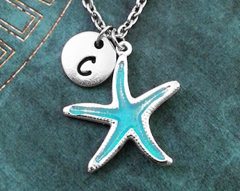 May include: A silver chain necklace with a blue and silver starfish charm and a silver disc charm with the letter "C" on it.