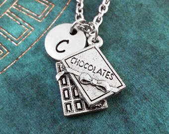 May include: A silver necklace with a charm that says "Chocolates" and a silver charm with the letter "C".