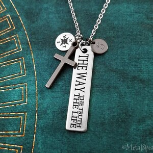 May include: Silver necklace with a cross charm, a compass charm, a personalised initial charm, and a rectangular tag that reads "The Way The Truth The Life".