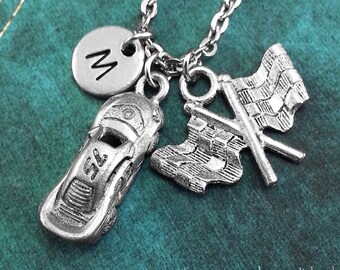 May include: Silver necklace featuring a race car charm, a chequered flag charm, and a personalised initial charm. The initial charm is a circle with the letter "M" in the centre.