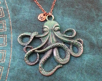 May include: A copper-toned octopus pendant necklace with a green patina finish. The necklace features a small copper charm with the letter 'W' on it.