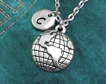 May include: A silver necklace with a globe charm and a letter 'C' charm. The necklace is on a teal background.
