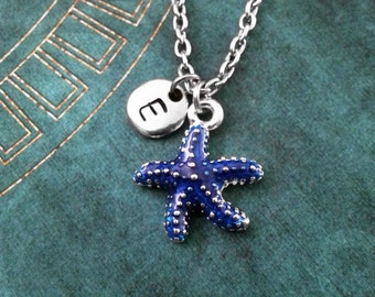 May include: A silver necklace with a blue enamel starfish charm and a silver disc charm with the letter 'E' on it.