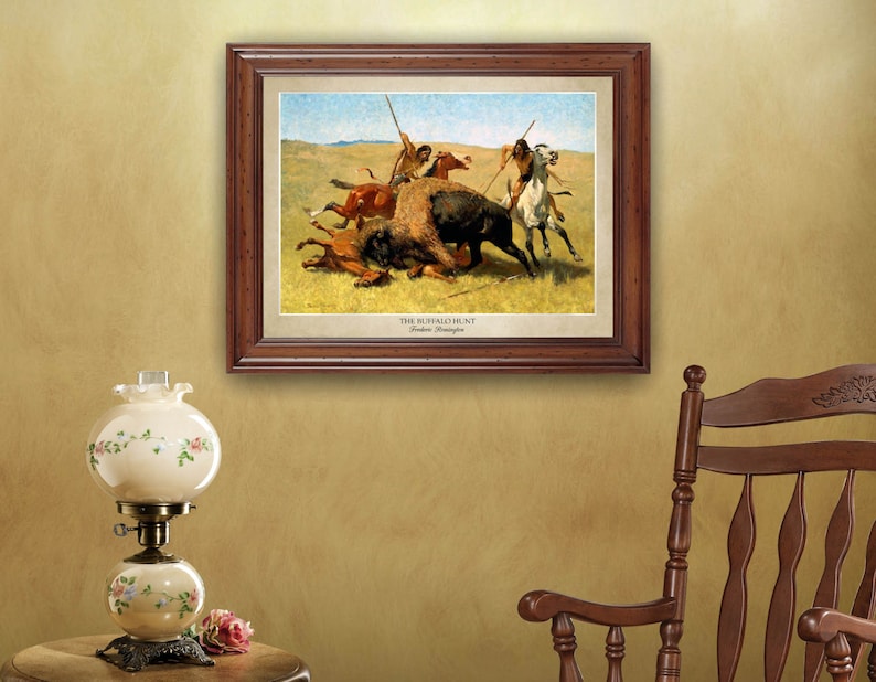 May include: A framed print of a painting depicting a buffalo hunt. The painting shows Native Americans on horseback, with spears, chasing a buffalo. The painting is titled "The Buffalo Hunt" by Frederic Remington.