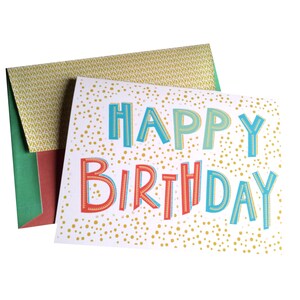 May include: A birthday card with the words "HAPPY BIRTHDAY" in blue, orange, and green. The card has a white background with gold polka dots. The envelope is green, red, and gold.