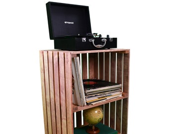 May include: A wooden crate shelf with two shelves, holding a record player, records, a globe, and books. The record player is black with a silver handle and the text "Polaroid" on the lid. The globe is green and brown. The books are brown and green with white text. The crate is made of natural wood with a light brown stain.