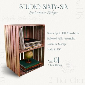 May include: A two-tier wooden record shelf made from reclaimed wood. The shelf is handcrafted in Michigan and can hold up to 120 records. It is delivered fully assembled and is made in the USA. The shelf is labeled "No. 01 2 Tier Cherry".