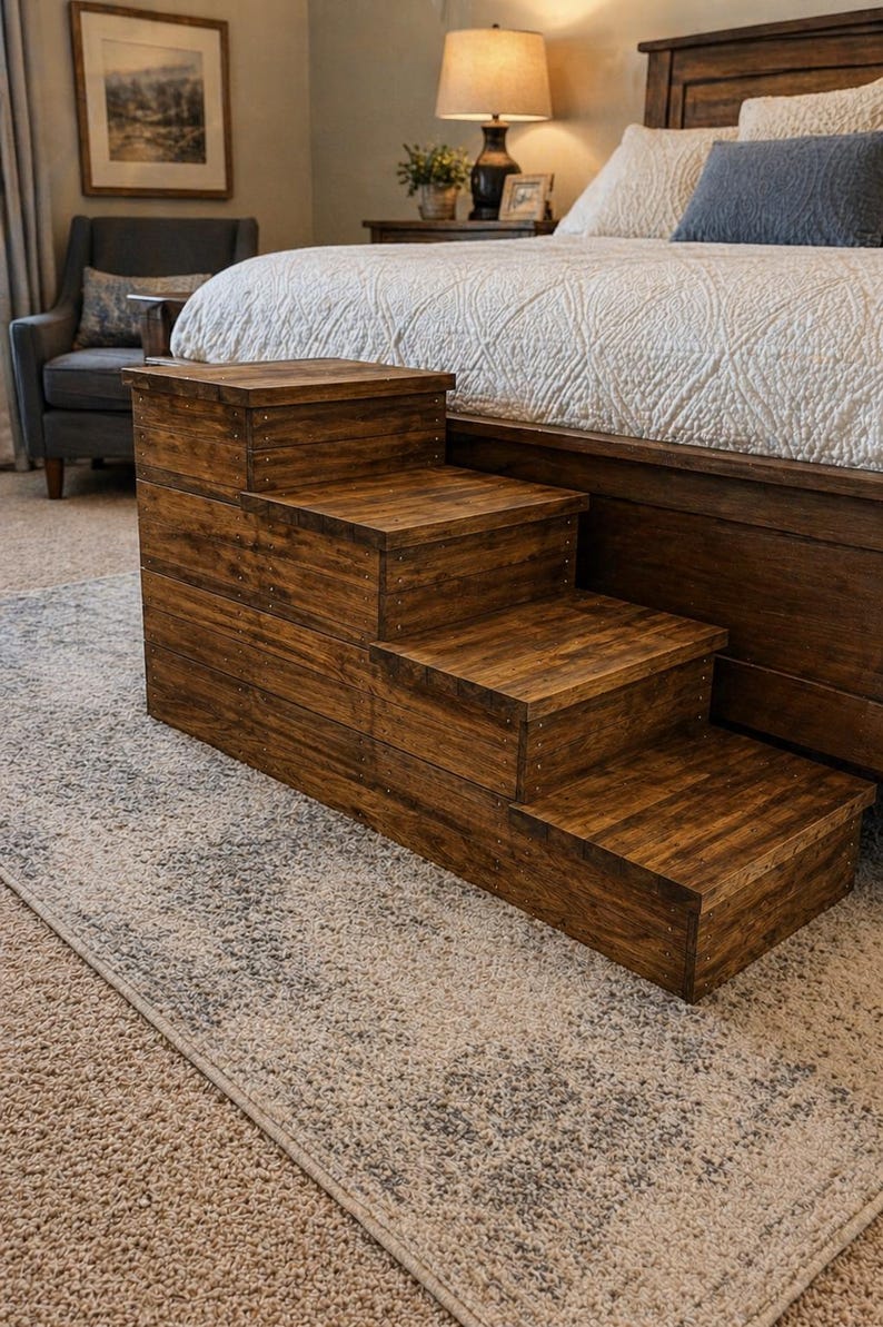 May include: A wooden pet step stool with four steps. The steps are stained a dark brown color and are constructed with visible wood grain. The step stool is placed next to a bed with a white comforter.