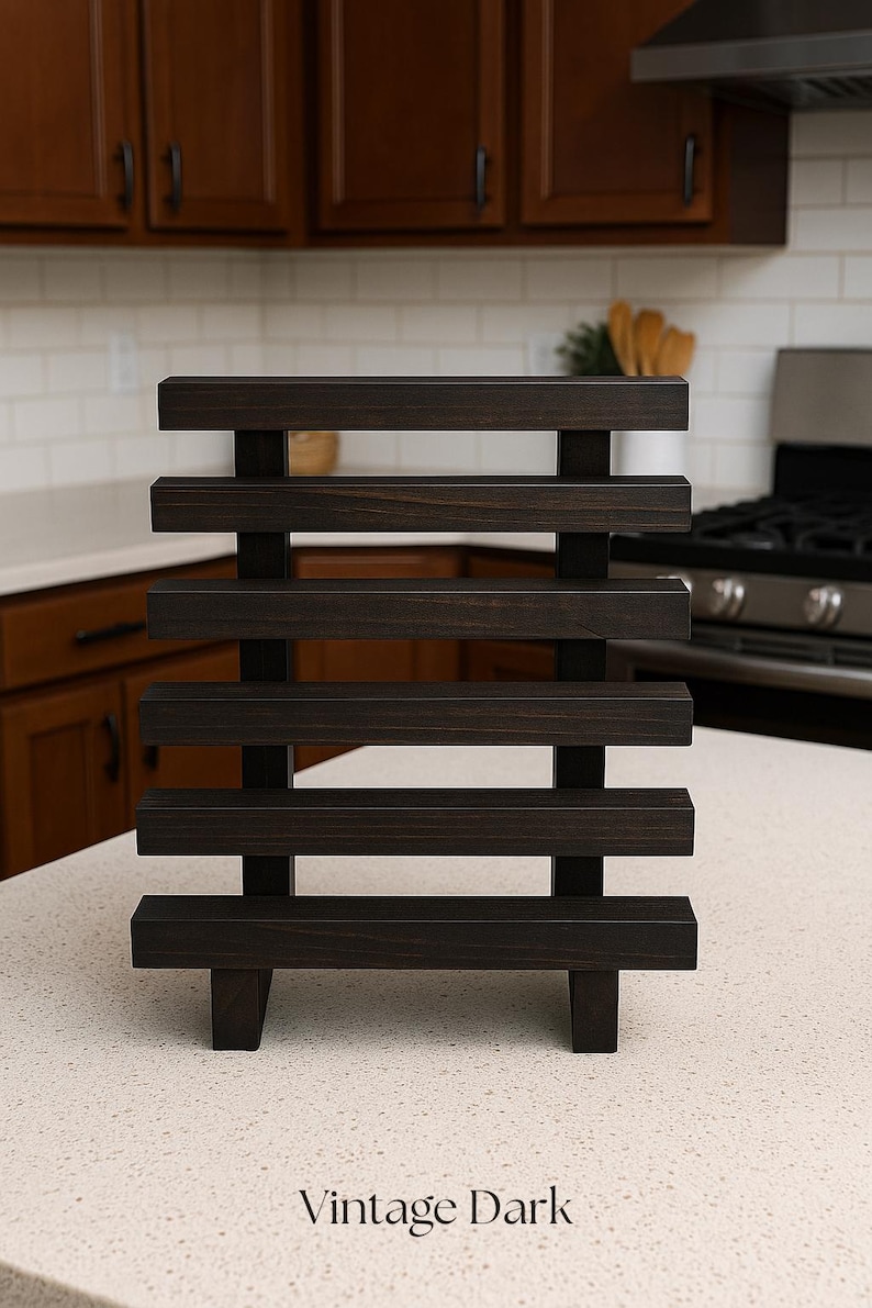 May include: Dark stained wooden shelf with horizontal slats and vertical supports. The shelf is labeled "Vintage Dark" in a white, sans-serif font. The shelf is on a white countertop in a kitchen.