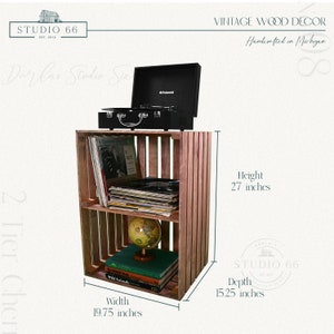 May include: A two-tier wooden crate shelf with a record player on top. The shelf is 27 inches tall, 19.75 inches wide, and 15.25 inches deep. The shelf is filled with records, books, and a globe.