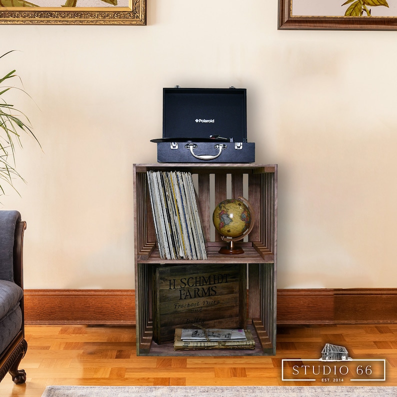 May include: A wooden crate shelf with two shelves, holding a record player, vinyl records, a globe, and a box labeled "H. Schmidt Farms".