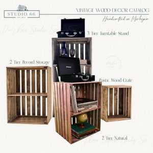 May include: Three wooden crates, each with two shelves, are arranged in a row. The crate on the left is a two-tier record storage unit. The middle crate is a three-tier turntable stand. The crate on the right is a two-tier natural crate. All three crates are made of rustic wood and have a natural finish.