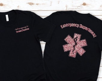 May include: Black t-shirt with a pink glitter star of life and the text "Emergency Department" on the back. The front of the shirt has a pink glitter heartbeat with the text "Emergency Department" on the front.