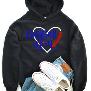 May include: Black hooded sweatshirt with a white heart and the text "Baseball Mom" in blue and red lettering. The heart has a red baseball stitch design.