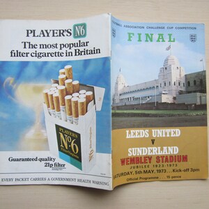 May include: Vintage advertisement for Player's No. 6 cigarettes, featuring a pack of cigarettes with the text "The most popular filter cigarette in Britain." The image also includes a football program for the Leeds United vs. Sunderland match at Wembley Stadium.