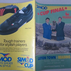 May include: A yellow and blue program for the Simod Cup Final between Luton Town and Reading. The game was played at Wembley Stadium on March 27th, 1988. The program features a photo of the two teams holding the trophy.