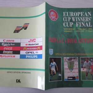 Könnte beinhalten: Ein grünes und weißes Programmcover für das Finale des Europapokals der Pokalsieger 1993. Das Cover zeigt das UEFA-Logo, den Text "Finale des Europapokals der Pokalsieger", das Datum "Mittwoch, 12. Mai 1993", den Ort "Wembley", die Anstoßzeit "19:15 Uhr" und die Mannschaften "Parma AC gegen Royal Antwerpen".