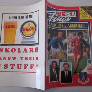May include: A red and white program for the Skol Final soccer game between Rangers and Aberdeen. The game was played on Sunday, October 23rd, 1988 at Hampden Park in Glasgow. The program features photos of the players and managers, as well as the Skol beer logo.