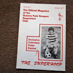 Könnte beinhalten: Ein Schwarzweißfoto eines Fußballspielers auf dem Cover eines Magazins namens "The Superhoop", dem offiziellen Magazin des Queens Park Rangers Supporters Club. Das Magazin ist aus dem Februar 1977 und enthält ein exklusives Interview mit Peter Eastoe.