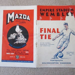 May include: A vintage programme for the 1939 Football Association Challenge Cup Final between Portsmouth and Wolverhampton Wanderers at Wembley Stadium. The programme features a red and white design with the text "Final Tie" and "Empire Stadium Wembley".
