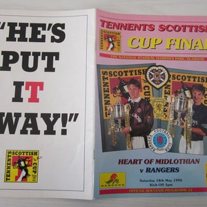 Könnte beinhalten: Ein Programmcover für das Tennent's Scottish Cup Finale 1996 zwischen Heart of Midlothian und Rangers. Das Cover zeigt ein Foto von zwei Spielern, die Trophäen halten, mit dem Text "Tennent's Scottish Cup Final" und "The National Stadium, Hampden Park, Glasgow".