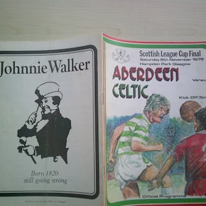May include: A programme for the Scottish League Cup Final between Aberdeen and Celtic, held on Saturday 6th November 1978 at Hampden Park in Glasgow. The programme features a drawing of a Celtic player in a green and white jersey and an Aberdeen player in a red jersey. The programme is sponsored by Johnnie Walker.