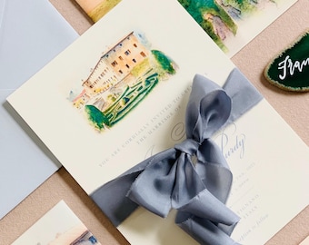 May include: Wedding invitation with a watercolor illustration of a building and garden, tied with a gray ribbon. Additional stationery includes a matching envelope, a wax seal, and a place card.