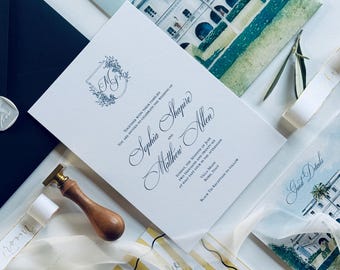 Op de afbeelding: Trouwuitnodigingsset met een hoofduitnodiging met elegant schrift en een bloemenmonogram. Inclusief RSVP-kaarten, gastendetailkaarten met aquarelillustraties en een geel gestreepte kaart met tekst. Decoratieve waszegels en linten maken de set compleet.