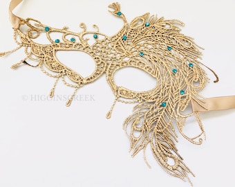 May include: Gold masquerade mask with a peacock feather design and teal blue rhinestones.