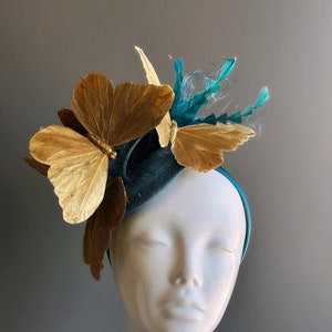 Butterfly tea party fascinator hat in teal and gold.