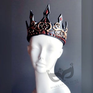 Black kind or queen crown for cosplay Halloween costumes. It’s made of rubber base and hand painted in gold and red glitter trim. There is Velcro in the back for adjusting. The base is black and sits on the head of the mannequin.