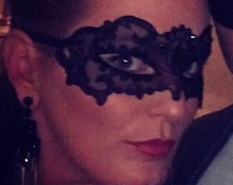 Könnte beinhalten: Ein Paar trägt Masken. Die Frau trägt eine schwarze Spitzenmaske und der Mann trägt eine schwarze Samtmaske. Beide lächeln.
