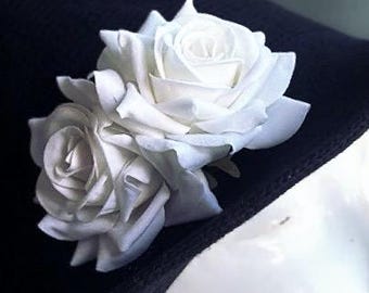 Puede incluir: Un broche de flores de tela blanca con dos rosas. El broche está sujeto a un sombrero negro. El texto "Clip ONLY Hat not included" es visible en la imagen.