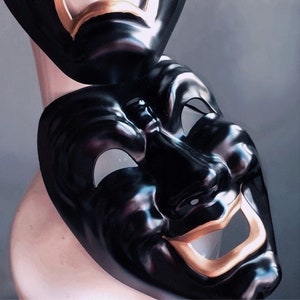 May include: Two black theatrical masks, one with a sad expression and the other with a happy expression. Both masks have gold accents around the mouth.