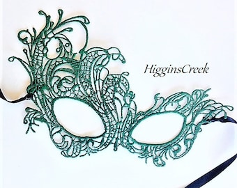 May include: A green lace masquerade mask with a black ribbon attached. The mask has a delicate, intricate design.