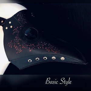 May include: Black leather plague doctor mask with a red floral design and a round eye hole. The mask has a long beak and is decorated with metal eyelets. "Basic Style" is written in white text below the mask.