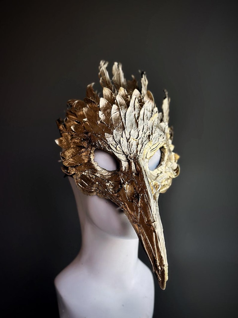Gold bird mask with feathers.