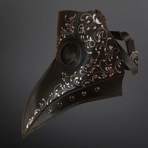 May include: A black leather plague doctor mask with a silver floral design and a clear eye piece. The mask has a long beak and is secured with a leather strap.