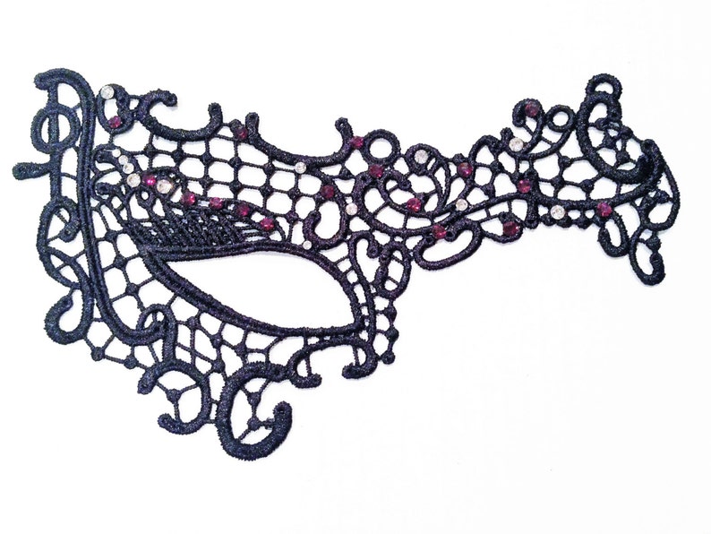 Peut inclure: Masque de bal de dentelle noire avec des strass et des bijoux rouges.